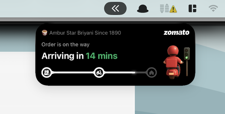 Live Activity on macOS 26 shows Zomato food order arriving in 14 minutes with a scooter rider icon.